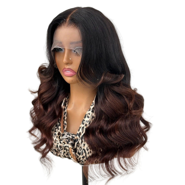 Mannequin head with a black and brown ombre wig on a white background