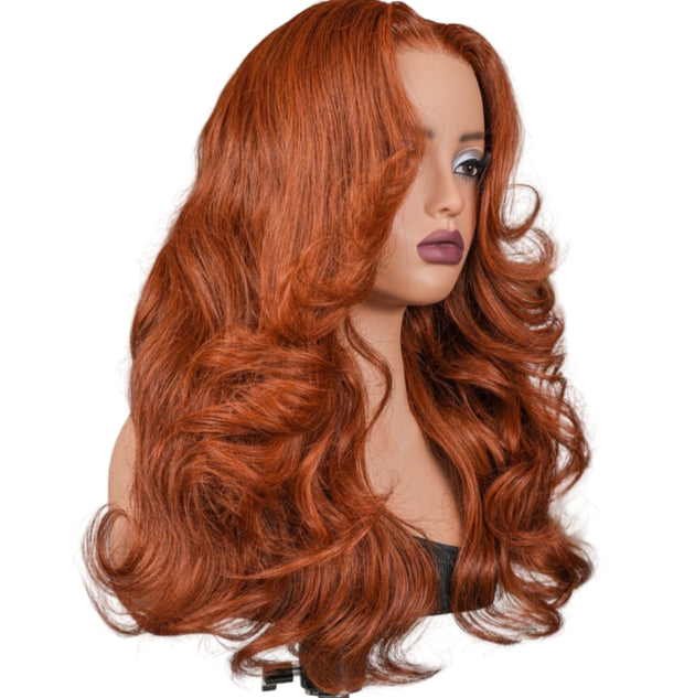 Red wig on a mannequin head against a plain background
